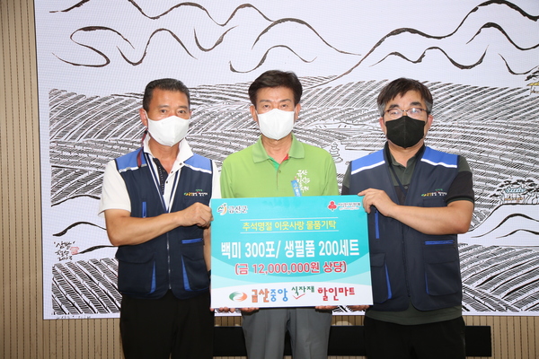 <사진> 금산중앙식자재할인마트 조채연 대표(오른쪽)이 물품을 기탁하고 박범인 금산군수(가운데)와 기념사진을 찍고 있다.