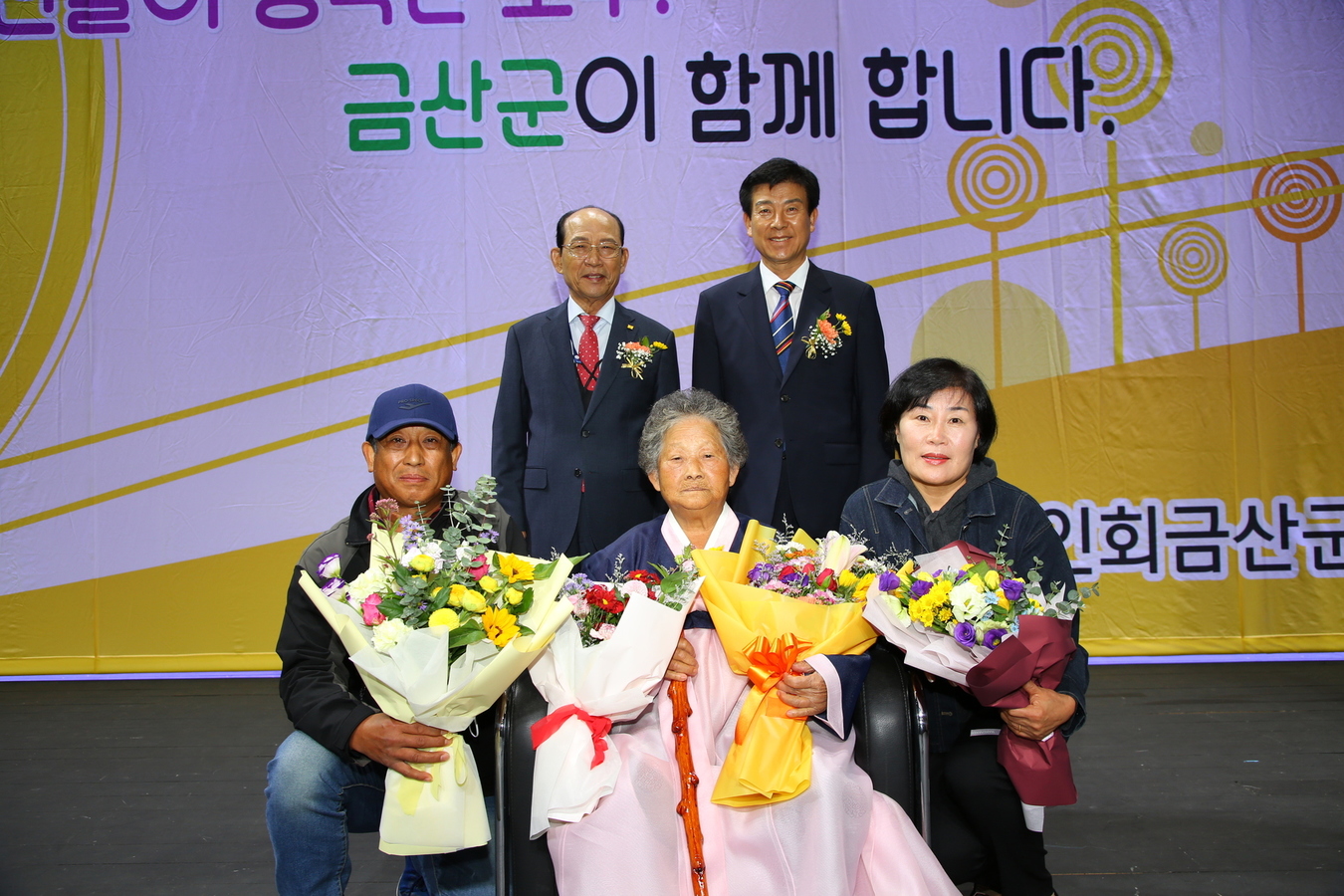 <사진> 제26회 노인의 날 행사에서 황성분씨(앞줄 왼쪽 두 번째)가 청려장을 받고 박범인 금산군수와 기념사진을 찍고 있다.
