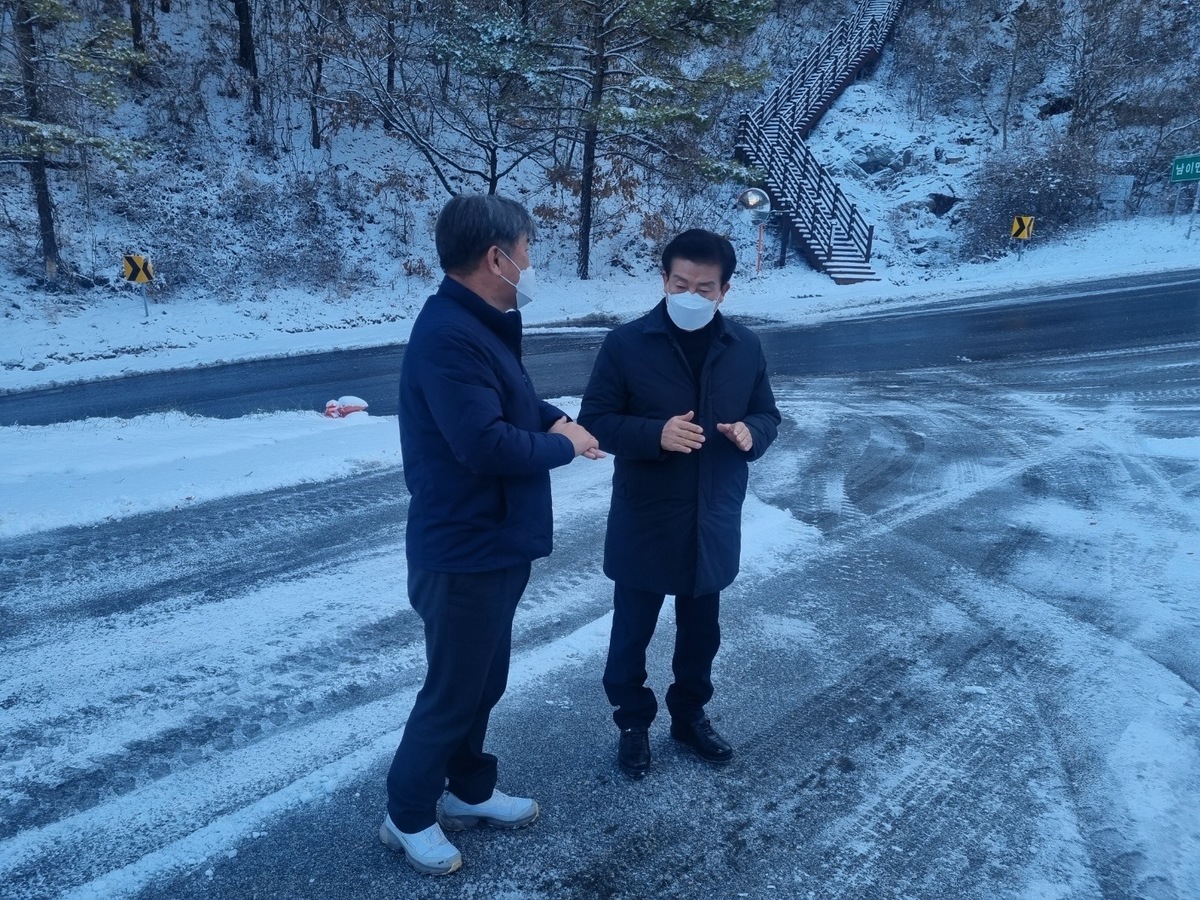 <사진> 박범인 금산군수가 14일 오전 7시 30분 금산읍 양지리 일원 국도에서 김선호 도로팀장의 보고를 듣고 있다.