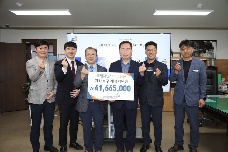 <사진> 한국지방재정공제회 조상희 중부권광역센터장(왼쪽 세 번째)이 지원금을 전달하며 이종규 금산부군수(오른쪽 세 번째)와 기념사진을 찍고 있다.